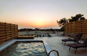 Agios PadeleimonにあるLIViT Condo Elafonisiのプール(椅子2脚付)が備わり、夕日を望めます。