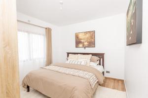 a white bedroom with a bed and a window at SOFT LaNDING in Tatu City