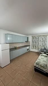 una cocina con armarios azules y un sofá en una habitación en Brisa B, en Agüimes
