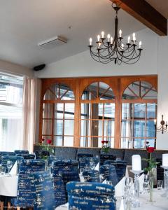 a dining room with blue chairs and a chandelier at Rosendal Fjordhotel in Rosendal +24 photos