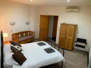 a bedroom with a large white bed and a chair at Ceret Beautiful Spacious House & Courtyard BBQ in Céret