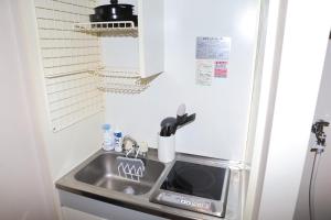 a kitchen with a sink and a refrigerator at Cooee Chigasaki 406 in Chigasaki