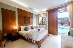 een slaapkamer met een bed en een zwembad bij Kakul Villas & Suites Ubud in Ubud