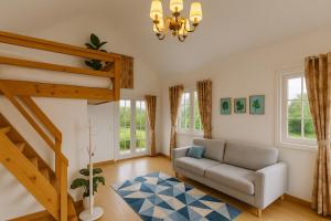 a living room with a couch and a staircase at ASTON X-CLUSIVE Cottage in Phra Nakhon Si Ayutthaya