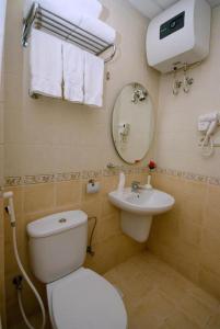 a bathroom with a white toilet and a sink at Fundaq Al Fajar Al Badea 5 in Makkah