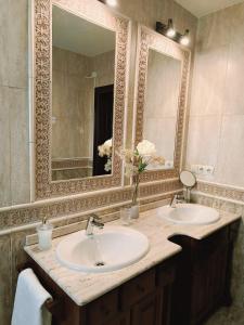 a bathroom with two sinks and a large mirror at Casa Rural Vista Castillo in Almonacid de Toledo