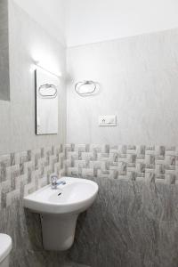 a white bathroom with a sink and a toilet at Stay Above by Alchemy Homes in Cochin