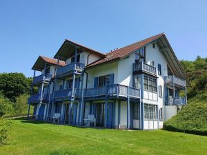 ein großes Gebäude mit blauen Balkonen und einem Hof in der Unterkunft Ferienland Sonnenwald Ferienwohnung im Sonnenwald Apartment 5 in Langfurth 