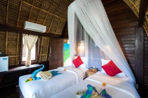a bedroom with two beds and a window at Dream Beach Kubu & SPA by ABM in Nusa Lembongan +101 photos