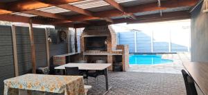 a patio with a table and a grill and a pool at Murray Guest Suite in Goodwood