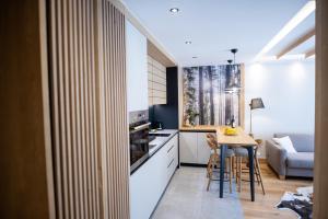 a kitchen with white cabinets and a table with chairs at BiancaNeve Jahorina in Jahorina