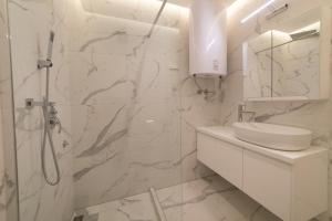 a white bathroom with a shower and a sink at Vule Vu Collection in Bajina Bašta +69 photos