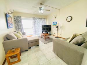 salon z dwiema kanapami i telewizorem w obiekcie Beach Front Holiday Apartment, Stella Maris, Beach Road, Amanzimtoti w mieście Amanzimtoti