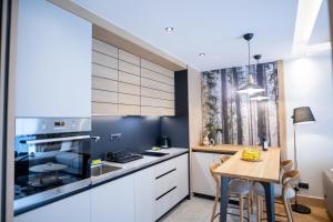 a kitchen with white cabinets and a wooden table at BiancaNeve Jahorina in Jahorina