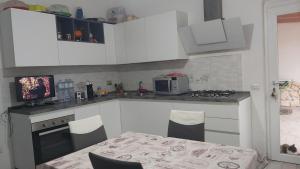 a kitchen with white cabinets and a table and a microwave at Casa Isabel IUN P9639 in Olbia +14 photos