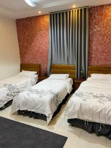 a bedroom with two beds and a window at Al Dana Plaza Villas in Taif +57 photos