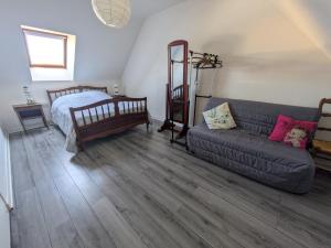 ein Wohnzimmer mit einer Couch und einem Bett in der Unterkunft Maison de vacances 400 m de la plage et du port de la Turballe in La Turballe