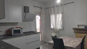 a kitchen with a microwave and a table with chairs at Casa Isabel IUN P9639 in Olbia