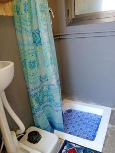 a shower with a blue shower curtain in a bathroom at Yurta con uso piscina e vista meravigliosa in Dicomano +39 photos