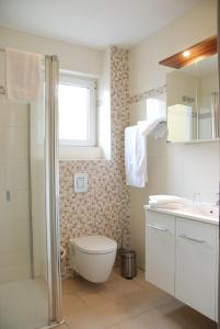 a bathroom with a toilet and a sink and a shower at Apartment Hotel Rüther in Papenburg