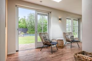 a living room with rocking chairs and a sliding glass door at Groeneweg 6, Wissenkerke in Wissenkerke