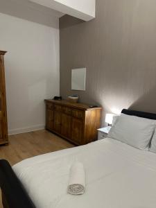 エディンバラにあるDouble room with garden In The Heart of Edinburghのベッドルーム(白いベッド1台、木製ドレッサー付)
