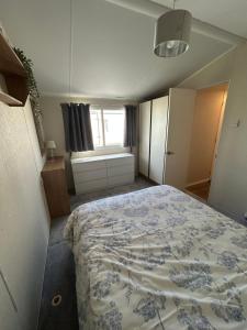 une chambre avec un lit avec une couverture bleue et blanche dans l'établissement 2 Bedroom Caravan 6 Birth The Wolds Ingoldmells Skegness - No pets free WiFi, à Ingoldmells