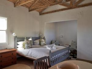 a bedroom with a large bed in a room at Cedarpeak Mountain cottages in Piketberg