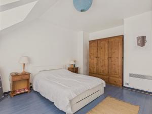 a bedroom with a bed and a wooden cabinet at Maison pour 4 avec jardin sur Guerande in La Baule
