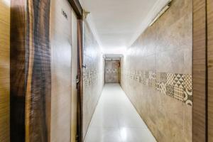 a corridor of a hallway with tiles on the walls at Hotel O A One Guest House in Kolkata