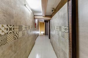 a corridor in a building with tiles on the walls at Hotel O A One Guest House in Kolkata