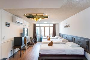a hotel room with four beds and a flat screen tv at SK Boutique Mahanakhon in Bangkok +29 photos