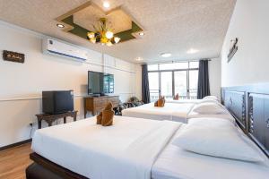 a hotel room with two beds and a flat screen tv at SK Boutique Mahanakhon in Bangkok