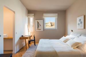 a bedroom with a bed and a desk and a window at Al Monumento in Modica