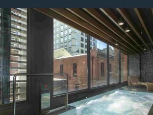 a hot tub in a building with a large window at 3 Bedroom Apartment Opposite Melbourne Central in Melbourne