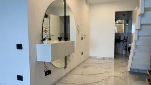 pasillo con espejo en la pared y lavabo en Giudecca Suite Sea View, en Cefalú