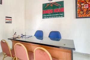a reception desk with blue chairs in a room at RedDoorz at Dimens House Sragen in Sragen