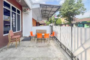 a patio with chairs and a table and a fence at RedDoorz at Dimens House Sragen in Sragen