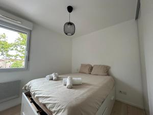 a white bedroom with a large bed with white pillows at Appartement Aux Portes de Toulouse in Plaisance-du-Touch