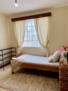 a bedroom with a bed with a window at Casa Solenda in Ruaka