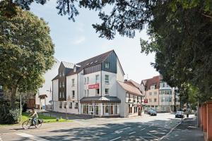 eine Person, die mit dem Fahrrad eine Straße hinunterfährt in der Unterkunft Hotel Zum Goldenen Ochsen am Schlossgarten in Aschaffenburg