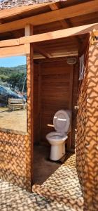 a bathroom with a toilet in a wooden building at iCampJal Beach Camp and Bar in Jal +87 photos