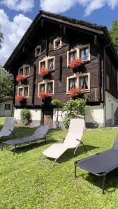 a group of chairs in front of a house at Chalet Piumogna in Faido