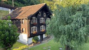 a house with flowers on the windows and a tree at Chalet Piumogna in Faido