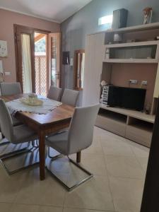 Un comedor con mesa y sillas de madera. en Casa Alessia, en SantʼAnna Arresi