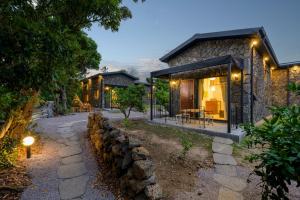 a stone house with a stone wall in front of it at 월영사계 in Seogwipo
