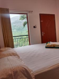 une chambre avec un lit et une grande fenêtre dans l'établissement Jungle Berg, à Kanthalloor