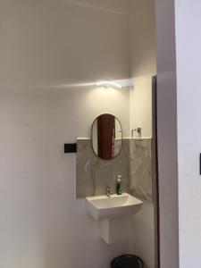 une salle de bain avec un lavabo et un miroir dans l'établissement Jungle Berg, à Kanthalloor