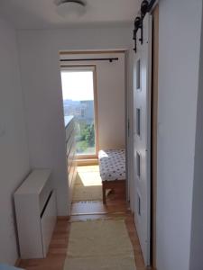 - un couloir avec une porte menant à une chambre avec une fenêtre dans l'établissement Apartmán pod Kolibou, à Bratislava