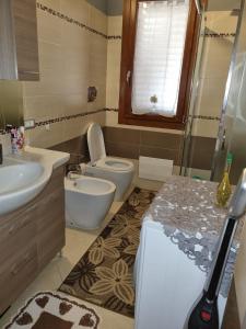 un baño con inodoro y lavabo en Casa Alessia, en SantʼAnna Arresi